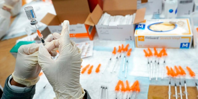 FILE - A Northwell Health registered nurse fills a syringe with a COVID-19 vaccine at a pop up vaccination site the Albanian Islamic Cultural Center, April 8, 2021, in the Staten Island borough of New York. 